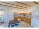 Open kitchen with wood beam ceilings, wooden cabinets, and stainless steel appliances at 2561 S Carey Way, Denver, CO 80222