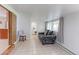 Bright living area features neutral paint, tile floors, and comfortable seating with backyard views at 2561 S Carey Way, Denver, CO 80222