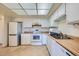 Bright kitchen featuring white appliances, cabinetry, and laminate countertops at 13902 E Marina Dr # 412, Aurora, CO 80014