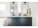 Elegant bathroom featuring double sinks, custom navy blue cabinets, and modern lighting for a luxurious feel at 2720 N Saint Paul St, Denver, CO 80205