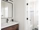 Elegant bathroom with a wood vanity, a sleek mirror, and a peek into the adjacent tiled shower at 2720 N Saint Paul St, Denver, CO 80205