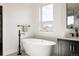 Bright bathroom with a sleek, freestanding tub beneath a large window, paired with a modern vanity at 2720 N Saint Paul St, Denver, CO 80205