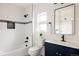 Modern bathroom features a tiled shower and tub, with a contrasting vanity and matte black hardware at 2720 N Saint Paul St, Denver, CO 80205