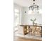 Elegant dining area featuring modern chandelier, ample natural light and stylish wood table and chairs at 2720 N Saint Paul St, Denver, CO 80205