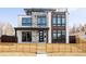 Contemporary home showcasing mixed materials, large windows, and a fenced front yard at 2720 N Saint Paul St, Denver, CO 80205