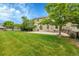 Spacious backyard with lush green lawn, patio, trees and partial fence at 11091 Clayton St, Northglenn, CO 80233