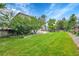 Large backyard with grass, a fence, a well maintained lawn and several trees at 11091 Clayton St, Northglenn, CO 80233