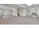 Unfinished basement with neutral carpet, white walls, staircase, and a sewing machine at 11091 Clayton St, Northglenn, CO 80233