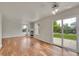 Open-concept living room with a fireplace, hardwood floors, and sliding glass doors to the backyard at 11091 Clayton St, Northglenn, CO 80233