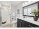 Remodeled bathroom with a glass shower, dark vanity, modern fixtures, and wood-look flooring at 11278 Clermont Dr, Thornton, CO 80233