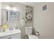 Neutral-toned half bathroom features modern fixtures, decorative mirror, and elegant wall art at 11278 Clermont Dr, Thornton, CO 80233