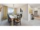 Bright dining room with a large window and stylish chandelier, adjacent to the home's staircase at 11278 Clermont Dr, Thornton, CO 80233