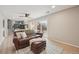 Open living space with wood floors, a leather sofa, and stairs leading to the kitchen at 11278 Clermont Dr, Thornton, CO 80233