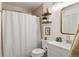 Cozy bathroom with floating shelves, decorative mirror and a shower and tub combination at 18391 E Kepner Pl # 205, Aurora, CO 80017