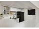 This kitchen features a stainless steel sink, open shelves, white cabinets, and a black refrigerator at 18391 E Kepner Pl # 205, Aurora, CO 80017