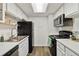 Efficient kitchen features modern appliances, white cabinets and a bright skylight at 18391 E Kepner Pl # 205, Aurora, CO 80017