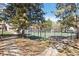 Outdoor tennis court with green surface, surrounded by trees and walking paths at residential complex at 18391 E Kepner Pl # 205, Aurora, CO 80017