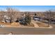 Aerial view of ranch house with yard, showcasing surrounding neighborhood and distant city skyline at 2753 S Meade St, Denver, CO 80236