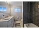 Modern bathroom with soaking tub, double vanity, and gray tile at 2753 S Meade St, Denver, CO 80236