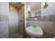 Clean bathroom with shower, pedestal sink, and updated tile at 2753 S Meade St, Denver, CO 80236