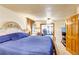 Cozy bedroom featuring a blue quilted bedspread and a doorway to another room at 233 Nome St, Aurora, CO 80010
