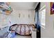 Cozy bedroom featuring a single bed, wire shelving, and natural light from a side window at 233 Nome St, Aurora, CO 80010