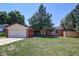 Charming brick home featuring a well-manicured lawn and mature tree, offering lovely curb appeal at 233 Nome St, Aurora, CO 80010