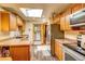Well-lit kitchen with wooden cabinets, stainless steel appliances, and a convenient laundry room access at 233 Nome St, Aurora, CO 80010
