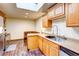 Bright kitchen with wooden cabinets, skylight, stainless steel appliances, and cozy dining nook for casual meals at 233 Nome St, Aurora, CO 80010