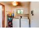 Convenient laundry room with modern washer, dryer, natural light, and storage for laundry supplies at 233 Nome St, Aurora, CO 80010