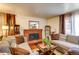 Cozy living room featuring a brick fireplace, comfortable sofas, and warm lighting for relaxed gatherings at 233 Nome St, Aurora, CO 80010