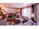 Warm and inviting living room featuring stylish sofas, curtains and a classic brick fireplace at 233 Nome St, Aurora, CO 80010
