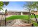 Manicured backyard with a brick home, awning covered windows, a path, and swing set at 1185 Yank St, Golden, CO 80401