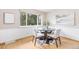 Kitchen/dining area with white paneling, a rustic table, and a view of the green trees outside at 1185 Yank St, Golden, CO 80401