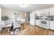 Bright eat-in kitchen featuring white appliances, stylish lighting, and hardwood floors at 1185 Yank St, Golden, CO 80401