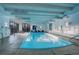 Indoor pool with large windows, lounge chairs, and bright lighting at 460 S Marion Pkwy # 706, Denver, CO 80209