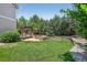 Lush backyard with manicured lawn, retaining wall, fire pit and covered patio at 4649 Spinning Wheel Dr, Brighton, CO 80601