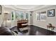 Elegant living room featuring hardwood floors, large windows, and a vintage piano at 4649 Spinning Wheel Dr, Brighton, CO 80601