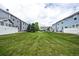 A large backyard area between two rows of townhomes featuring well-kept green grass at 19249 E 58Th Ave # D, Denver, CO 80249