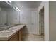 Bathroom featuring a large vanity, sink, mirror, and a storage closet at 19249 E 58Th Ave # D, Denver, CO 80249