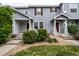 Charming townhome featuring a covered porch, landscaped front yard, and red door at 19249 E 58Th Ave # D, Denver, CO 80249