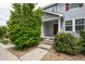 Exterior of townhome featuring a front porch, red door, and fresh landscaping at 19249 E 58Th Ave # D, Denver, CO 80249