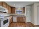 Well-lit kitchen with wood cabinets, modern appliances, white walls and wood-look flooring at 19249 E 58Th Ave # D, Denver, CO 80249