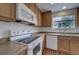 Sunlit kitchen featuring wood cabinets, modern appliances, and a view of the outdoors from the window at 19249 E 58Th Ave # D, Denver, CO 80249