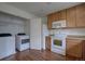 Spacious kitchen featuring a laundry closet, wood cabinets, modern appliances, and wood floors at 19249 E 58Th Ave # D, Denver, CO 80249