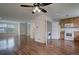 Open concept living room featuring wood floors, a ceiling fan and an adjacent kitchen with modern appliances at 19249 E 58Th Ave # D, Denver, CO 80249