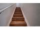 A clear view of hardwood stairs featuring white risers and railing at 19249 E 58Th Ave # D, Denver, CO 80249
