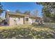 This backyard features mature landscaping with a patio, grass, and sprinklers at 5461 S Youngfield Ct, Littleton, CO 80127