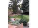 Beautiful backyard featuring a birdhouse, mature trees, and colorful flower beds, ideal for relaxation at 5461 S Youngfield Ct, Littleton, CO 80127