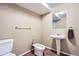 A clean bathroom featuring a toilet, bidet, pedestal sink, towel rack, and a modest mirror at 5461 S Youngfield Ct, Littleton, CO 80127